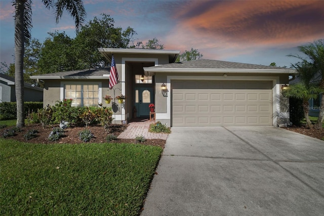 prairie-style home featuring a garage, driveway, and stucco siding