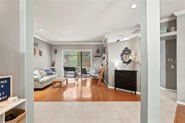 tiled living area featuring visible vents, crown molding, and baseboards