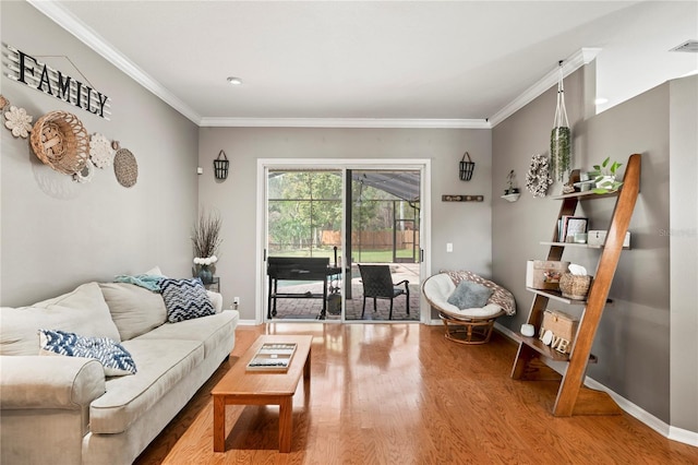 living room with baseboards, wood finished floors, and crown molding