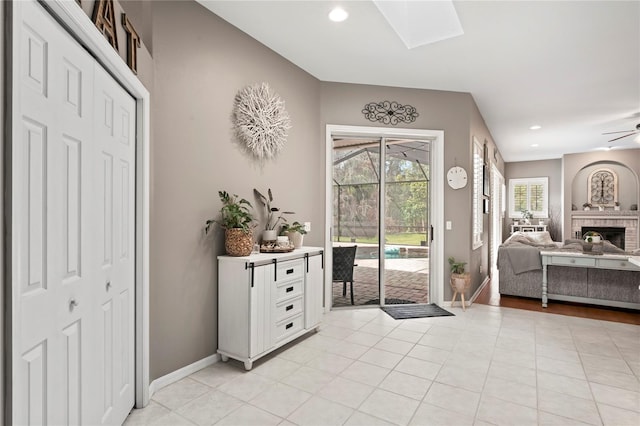 foyer entrance with light tile patterned flooring, recessed lighting, a skylight, and baseboards