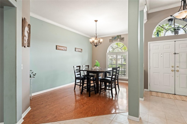 dining space with an inviting chandelier, light tile patterned floors, baseboards, and ornamental molding