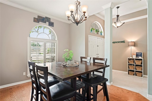 dining room featuring light wood-type flooring, baseboards, a notable chandelier, and ornamental molding