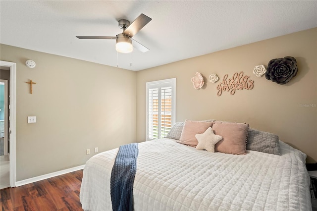 bedroom with a ceiling fan, wood finished floors, and baseboards