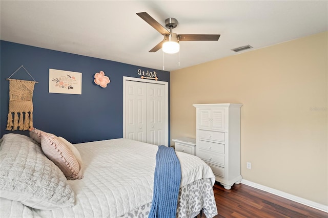 bedroom featuring dark wood-style floors, visible vents, baseboards, ceiling fan, and a closet