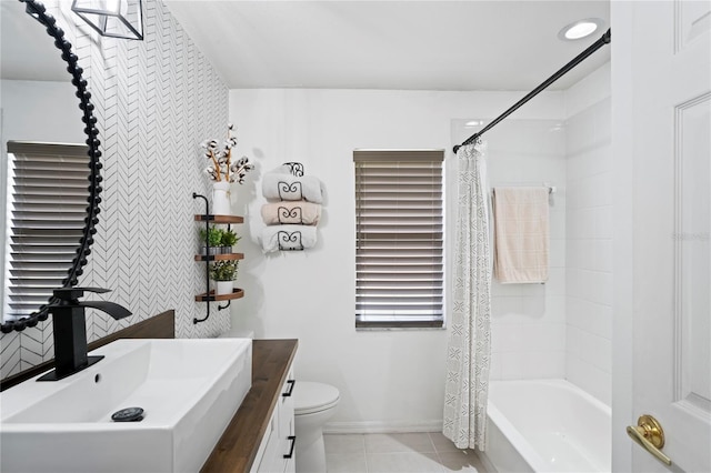 full bathroom with shower / bath combo with shower curtain, toilet, tile patterned flooring, baseboards, and vanity