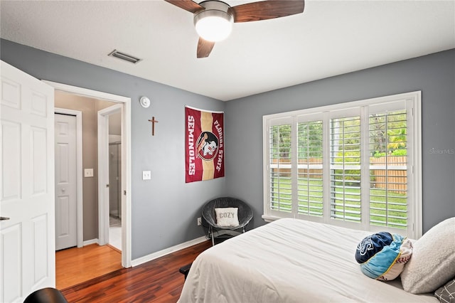 bedroom with dark wood-style floors, visible vents, ceiling fan, and baseboards