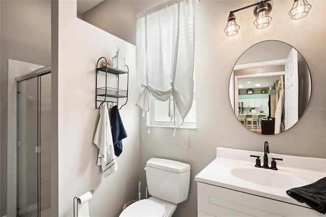 bathroom with a stall shower, toilet, and vanity