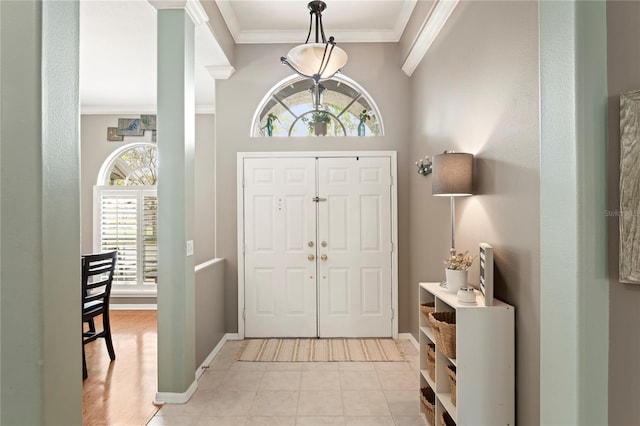 entrance foyer with light tile patterned floors, baseboards, and ornamental molding