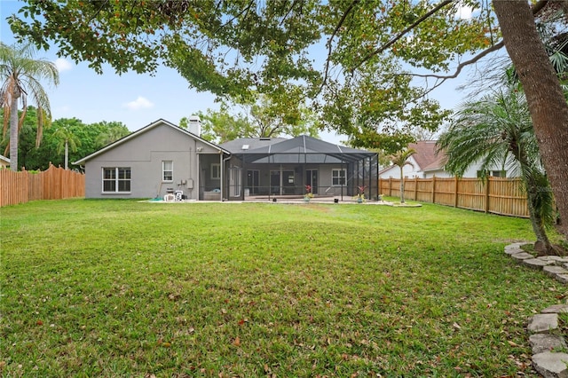 view of yard featuring glass enclosure and a fenced backyard