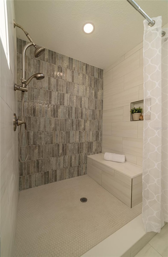 full bath with tile patterned flooring and a tile shower