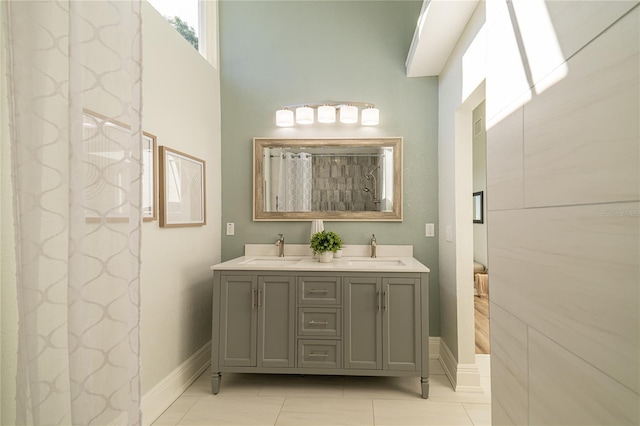 full bathroom featuring double vanity, baseboards, a shower with curtain, and a sink