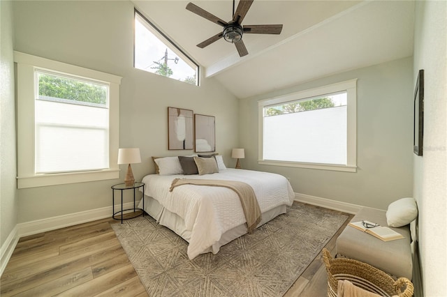 bedroom with multiple windows, light wood-type flooring, baseboards, and ceiling fan