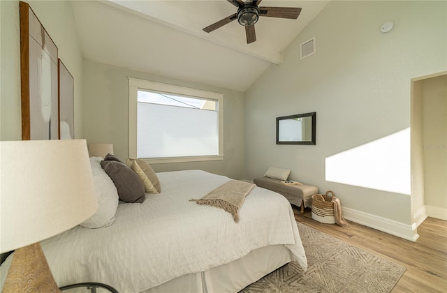 bedroom with visible vents, baseboards, vaulted ceiling, wood finished floors, and a ceiling fan