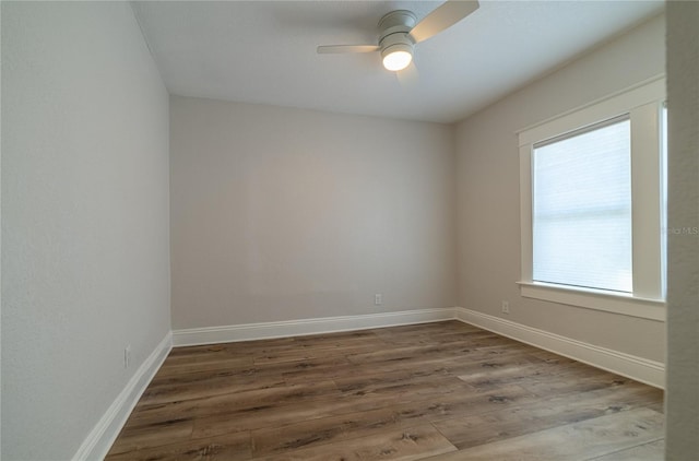 spare room featuring baseboards, ceiling fan, and wood finished floors