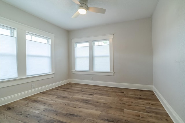 unfurnished room featuring wood finished floors, baseboards, and ceiling fan