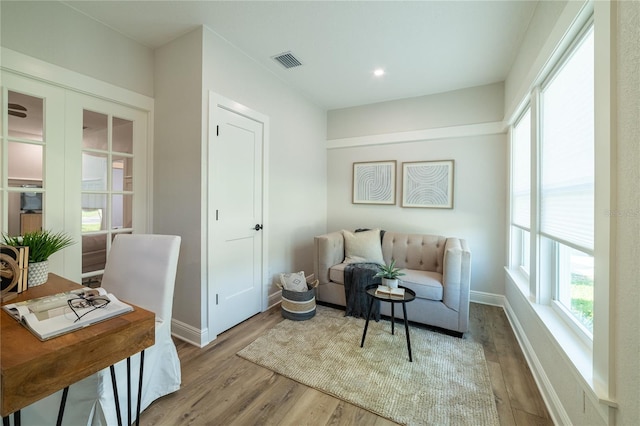 living area featuring visible vents, baseboards, and wood finished floors