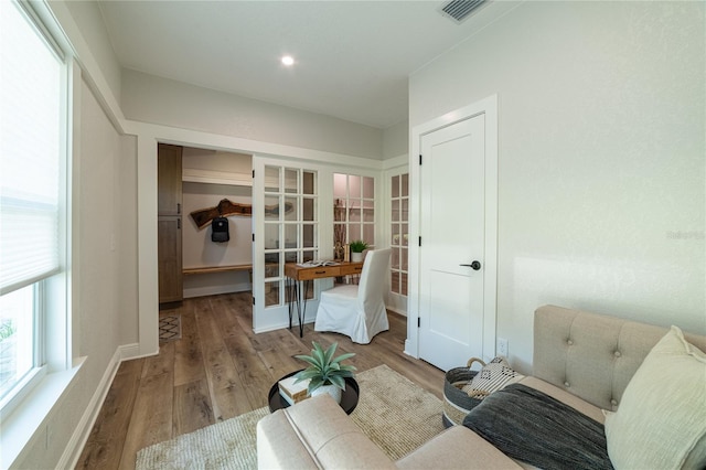 sitting room featuring visible vents, french doors, baseboards, and wood finished floors