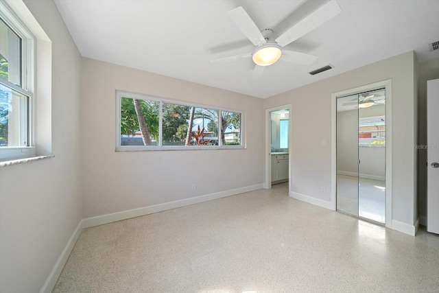 unfurnished bedroom featuring visible vents, speckled floor, a closet, and baseboards