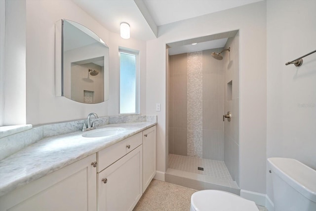 full bath featuring a tile shower, toilet, and vanity