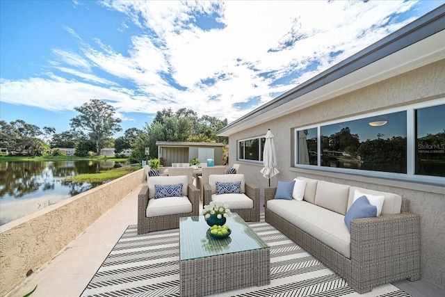 view of patio featuring outdoor lounge area, an outbuilding, and a water view