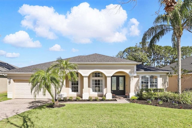 view of front facade featuring stucco siding, driveway, a front yard, and an attached garage