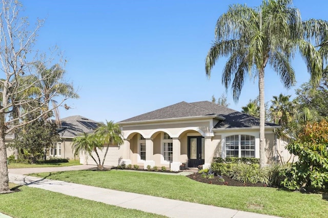 view of front of home featuring a garage, stucco siding, driveway, and a front lawn