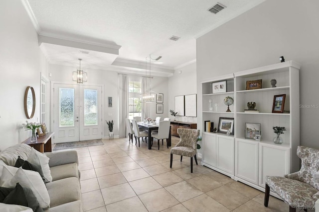 living area featuring visible vents, a textured ceiling, an inviting chandelier, and ornamental molding