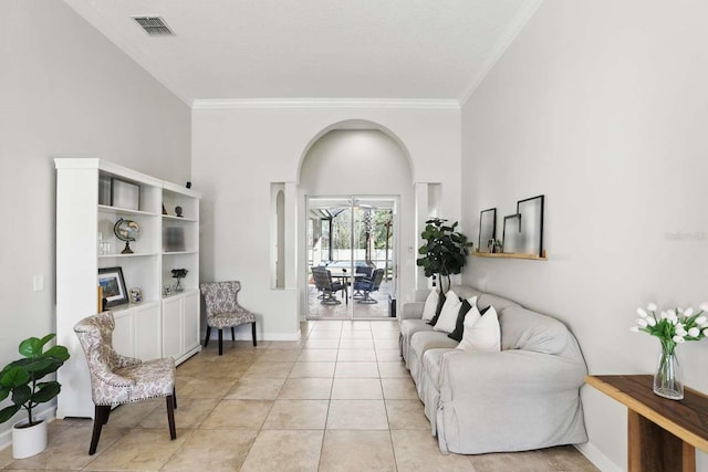 living area featuring light tile patterned flooring, visible vents, baseboards, and ornamental molding