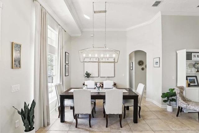 dining area with visible vents, arched walkways, ornamental molding, and light tile patterned flooring