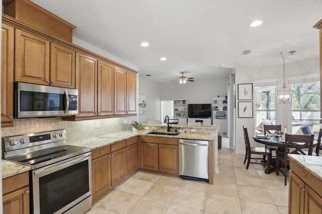 kitchen featuring brown cabinetry, appliances with stainless steel finishes, and a sink