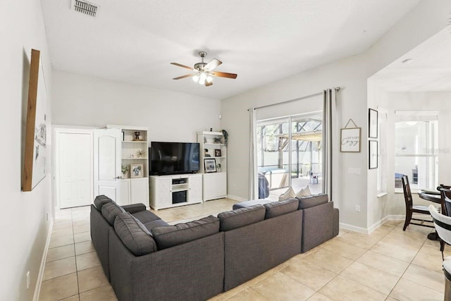 living room featuring light tile patterned floors, baseboards, visible vents, and ceiling fan