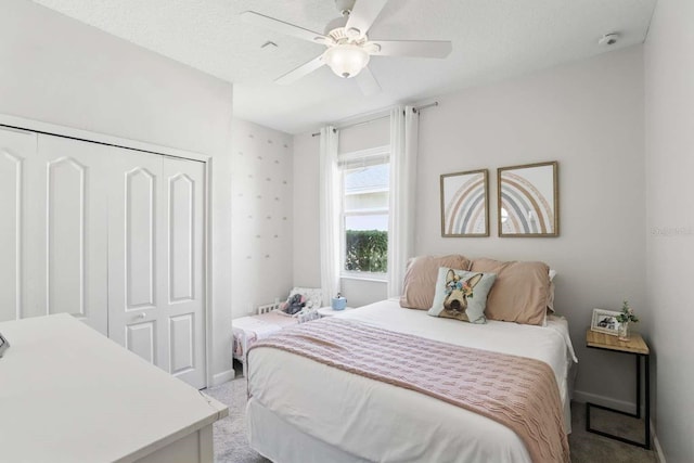 bedroom with a closet, baseboards, light colored carpet, and a ceiling fan