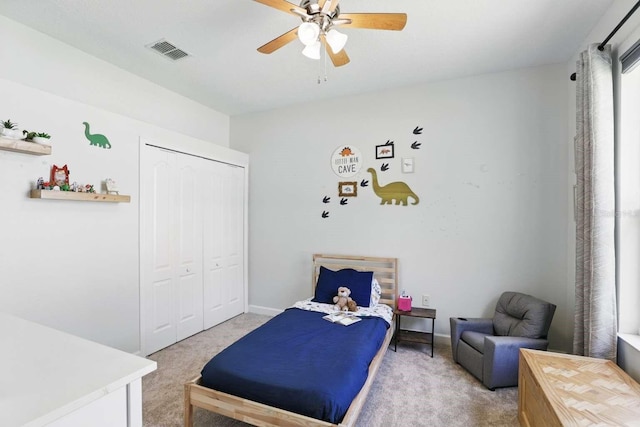 bedroom with a ceiling fan, baseboards, visible vents, a closet, and light carpet