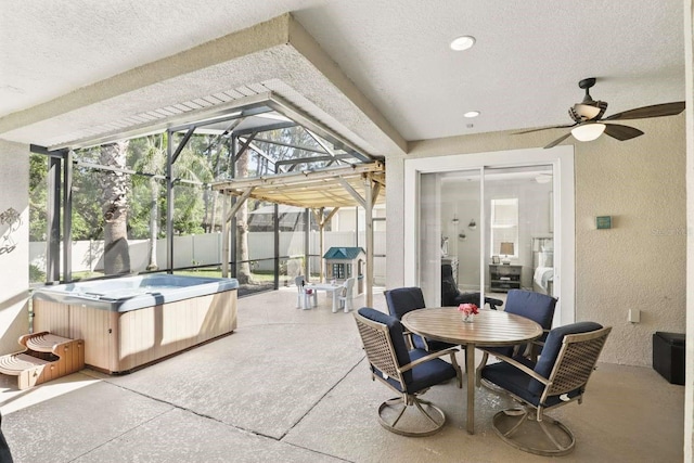 view of patio featuring glass enclosure, fence, and a hot tub