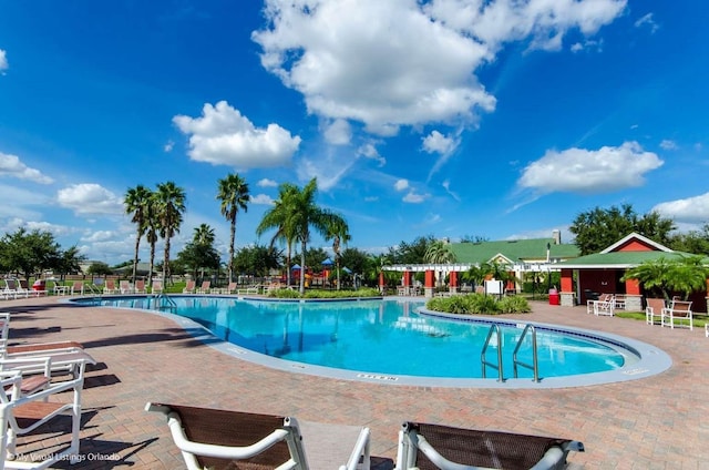 community pool with a patio and fence