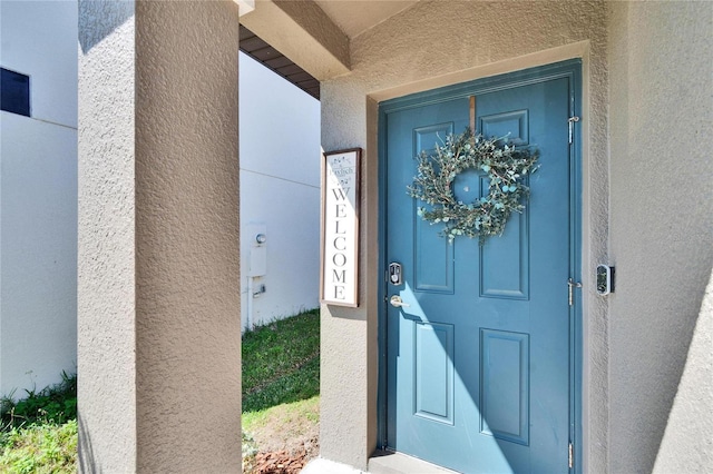 property entrance with stucco siding