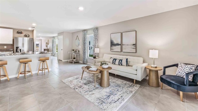 living area with light tile patterned flooring, recessed lighting, and baseboards