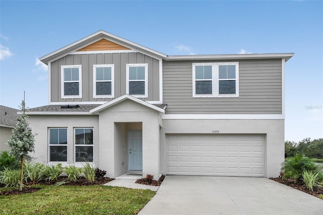 traditional-style house with an attached garage, driveway, and stucco siding