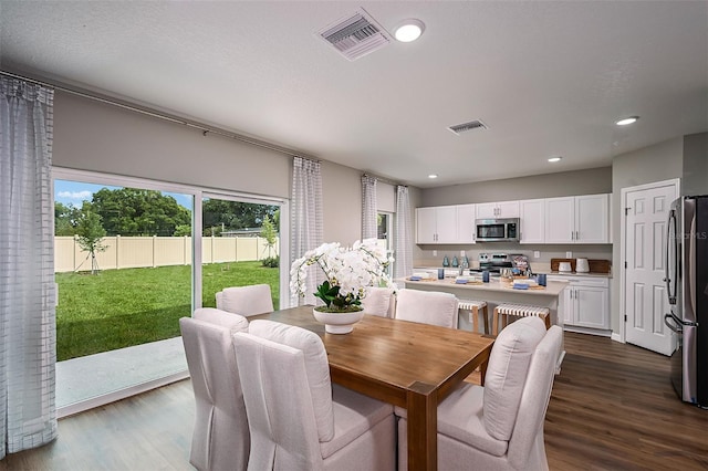 dining space featuring dark wood finished floors, visible vents, and recessed lighting