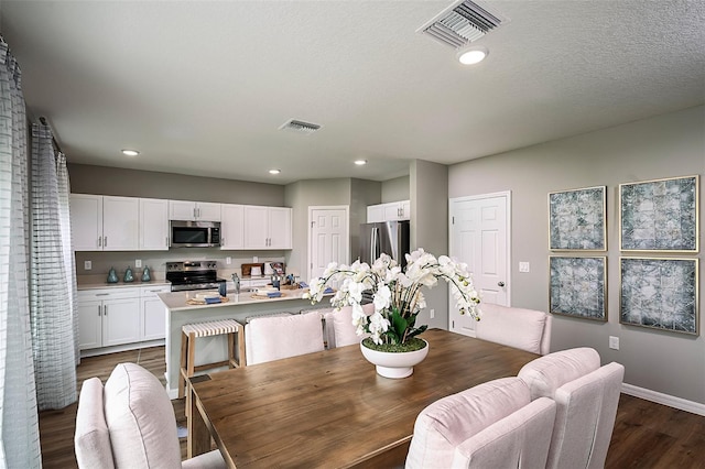 dining space with dark wood-style floors, visible vents, recessed lighting, and baseboards