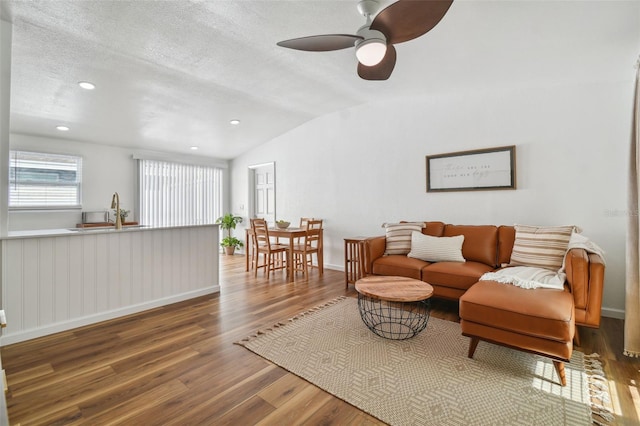 living room with a textured ceiling, wood finished floors, recessed lighting, ceiling fan, and vaulted ceiling