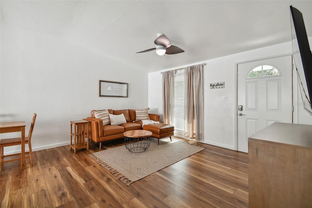 living room featuring baseboards, lofted ceiling, ceiling fan, and wood-type flooring