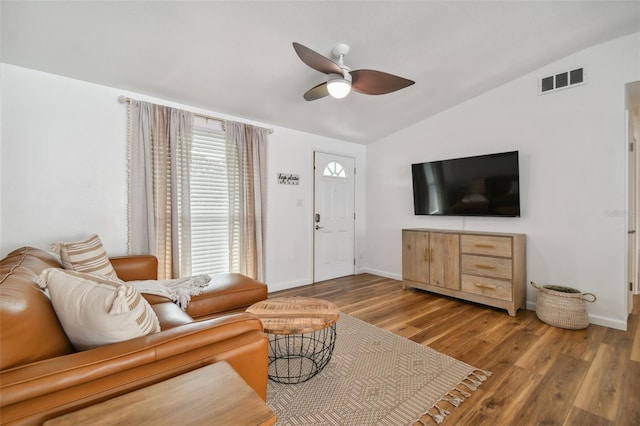 living room featuring visible vents, a ceiling fan, wood finished floors, baseboards, and lofted ceiling