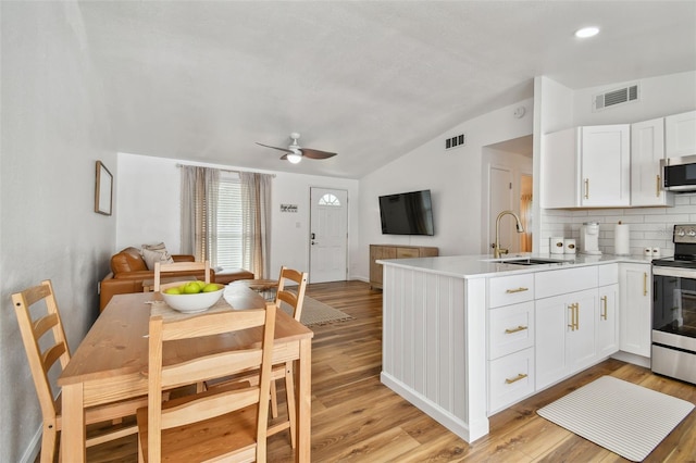 kitchen featuring a peninsula, visible vents, appliances with stainless steel finishes, and a sink