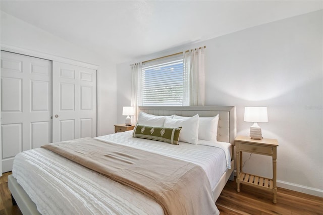 bedroom featuring a closet, baseboards, and wood finished floors