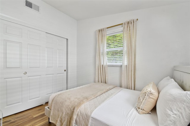 bedroom featuring visible vents and wood finished floors