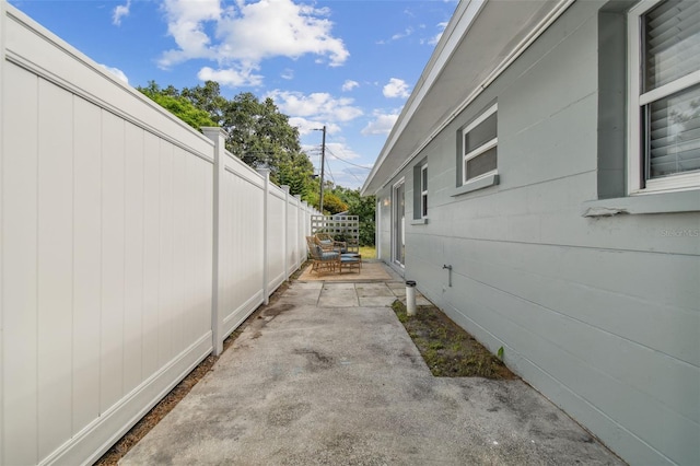 view of side of property featuring a patio and fence