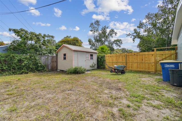 view of yard featuring a storage unit, an outbuilding, and a fenced backyard