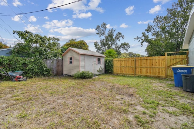 view of yard with a fenced backyard, a storage shed, and an outdoor structure