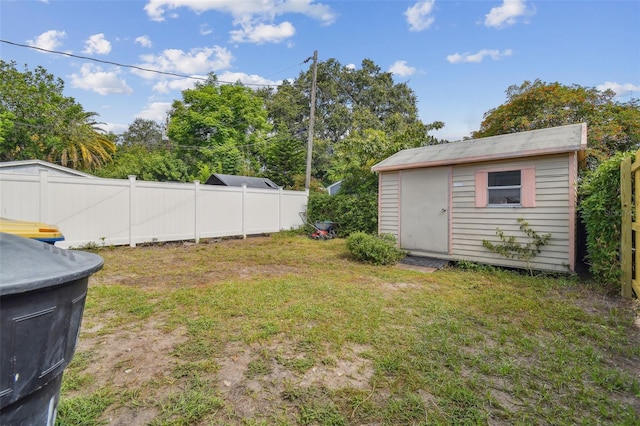 view of yard featuring a storage unit, an outbuilding, and fence